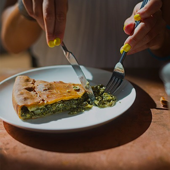 close up of person cutting quiche